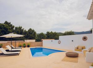 una piscina en un patio trasero con sillas y sombrilla en Villa en Cala Vadella Familias y Parejas, en Sant Josep de sa Talaia