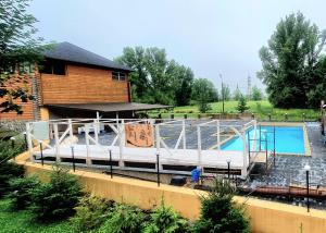 a large swimming pool with a house and a building at Kozatskiy Dvir in Stryi