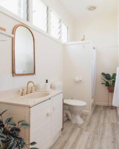 uma casa de banho branca com um lavatório e um WC em The Acres of Tooborac Cottage em Tooborac