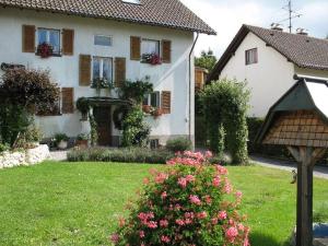 una casa blanca con flores en un patio en Haus am Brunnen, en Titisee-Neustadt