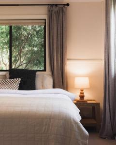 um quarto com uma cama e uma janela em The Acres of Tooborac Cottage em Tooborac