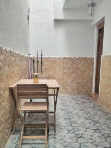 una mesa de madera y una silla en una habitación con pared en Apartamento El Reloj 1, en San Nicolás