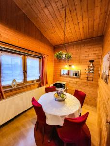 Deetz的住宿－Haus am Mühlenberg，一间带桌子和红色椅子的用餐室