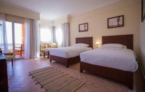 ein Hotelzimmer mit 2 Betten und einem Balkon in der Unterkunft The Cascades Golf Resort, Spa & Thalasso in Hurghada