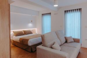 1 dormitorio con 1 cama y 1 sofá en Apartamentos Santa Isabel, en Murcia