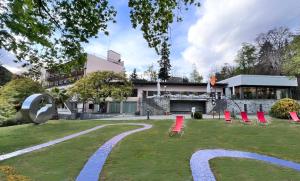 ein Garten mit roten Stühlen und einem Gebäude in der Unterkunft Hotel Monte Verità in Ascona