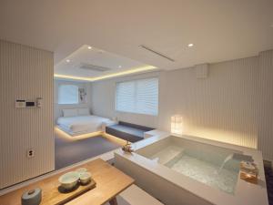 a bathroom with a tub and a bed in a room at The Leap Seoul Sadang in Seoul
