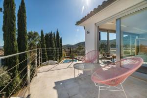 eine Terrasse mit 2 Stühlen und einem Tisch auf dem Balkon in der Unterkunft Villa Vista in Pollença