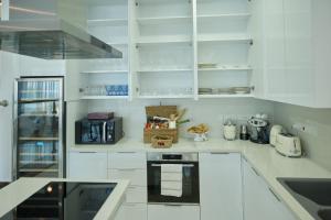 a white kitchen with white cabinets and appliances at Olymp Luxury Villa C in Kissonerga