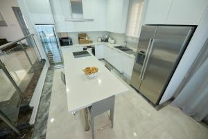 a kitchen with a white table and a refrigerator at Olymp Luxury Villa C in Kissonerga