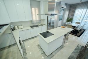 a white kitchen with a sink and a counter at Olymp Luxury Villa C in Kissonerga