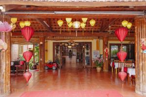 - un hall avec des lanternes en papier rouge, des tables et des chaises dans l'établissement Chez Loan Hotel, à Ninh Binh