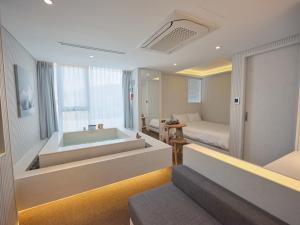 a bathroom with a bath tub and a bedroom at The Leap Seoul Sadang in Seoul