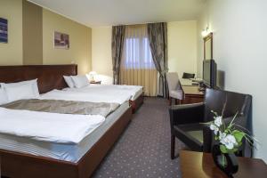 a hotel room with two beds and a desk at Garni Hotel Semlin B&B in Belgrade