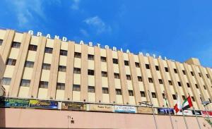 un gran edificio con una bandera delante de él en Grand Astoria Hotel en Dubái