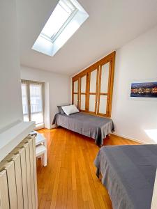 a bedroom with two beds and a skylight at Casa di Gio in Malgrate