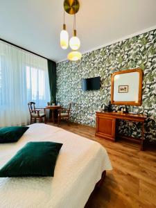 a bedroom with a bed and a mirror and a table at Septimia Hotels & Spa Resort in Odorheiu Secuiesc