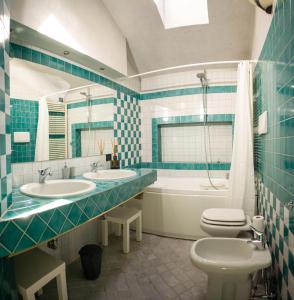a bathroom with two sinks and a toilet and a tub at Casa di Gio in Malgrate