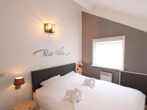 a bedroom with a white bed with a sign on the wall at Welcoming holiday home in Grou with bubble bath in Grou