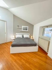 a bedroom with a bed and a wooden floor at Casa di Gio in Malgrate