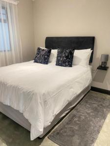 a bedroom with a large white bed with pillows at Mooi’s Monochrome in Walmer