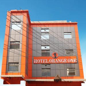 een gebouw met een hotelsinaasappelbord bij Hotel Orange One in Lahore