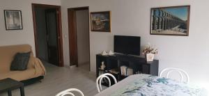 - un salon avec un canapé et une télévision dans l'établissement Villa "Luna de Segovia", à Leganés