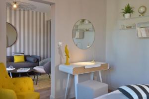 a living room with a table and a yellow chair at Le Général d'Elbée Hotel & Spa - Teritoria in Noirmoutier-en-l'lle