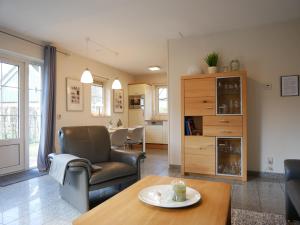 una sala de estar con un sofá y una mesa en Villa Lachmöwe, en Sint Maartensvlotbrug