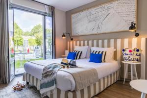 a bedroom with a large bed and a large window at Le Général d'Elbée Hotel & Spa - Teritoria in Noirmoutier-en-l'lle