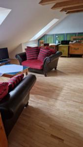 a living room with a black couch and red pillows at Boutique Penzión Slovenská - Penzión Bella Sicilia in Prešov