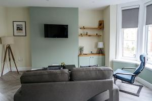 - un salon avec un canapé et une chaise dans l'établissement Beach Seaside Apartment sleeps 4 Lytham St Annes, à Lytham St Annes