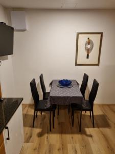 una mesa de comedor con sillas negras y una pintura en Savinja River Residence, en Ljubno