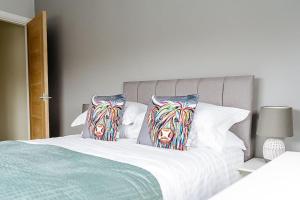 a bed with two pillows with a cow head on it at Beach Seaside Apartment sleeps 4 Lytham St Annes in Lytham St Annes
