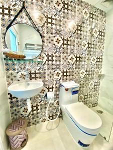 a bathroom with a toilet and a sink and a mirror at Hotel Phước Thịnh in Vĩnh Long