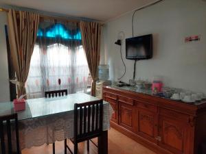 Pondok Seruni Kemanggisan Jakarta في جاكرتا: غرفة معيشة مع تلفزيون وطاولة وكراسي