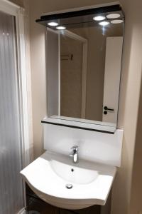 y baño con lavabo blanco y espejo. en Azureva Saint Cyprien, en Saint-Cyprien