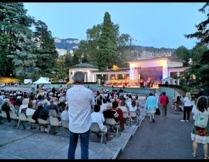 un hombre parado frente a una multitud de personas en L'Aixotique, en Aix-les-Bains