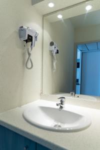 ein Waschbecken mit Spiegel und Telefon in der Unterkunft Résidence Azureva Piau Engaly in Aragnouet