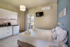 a bedroom with a large bed and a kitchen at Fedra Plakias in Plakias