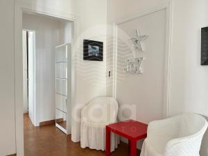 un soggiorno con tavolo rosso e 2 sedie di Appartamento Nike - spiaggia a 60m a Porto Cesareo