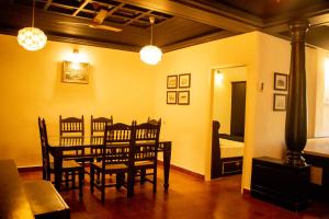 a dining room with a table and chairs and a bed at Fortbeach Service Apartments in Cochin