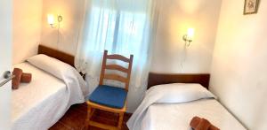 Cette petite chambre comprend deux lits et une chaise. dans l'établissement La Rotonda Garza, à Isla Canela