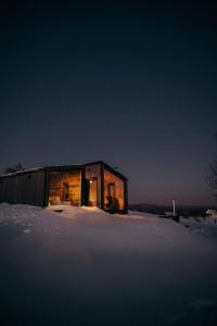 mały dom siedzący na pokrytym śniegiem polu w obiekcie Stare Szałasy w mieście Klikuszowa