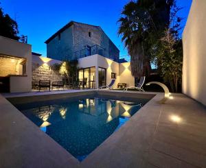 una casa con piscina di fronte a una casa di Cocon En Petite Camargue ad Aimargues