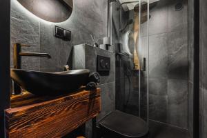 a bathroom with a black sink and a shower at Stare Szałasy in Klikuszowa