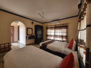 a hotel room with two beds and a window at Dharma Backpackers in Pokhara