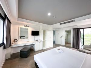 een grote kamer met een wit bed en een bank bij Rua Rasada Express in Trang