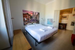 1 dormitorio con 1 cama con una pintura en la pared en Piazza Carracci, en Roma