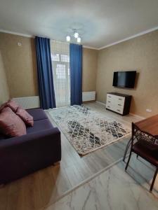 ein Wohnzimmer mit Sofa und Fernseher in der Unterkunft 2 комнатная Нурсат ЖК Алтын Шанырак in Schymkent + 23 Fotos